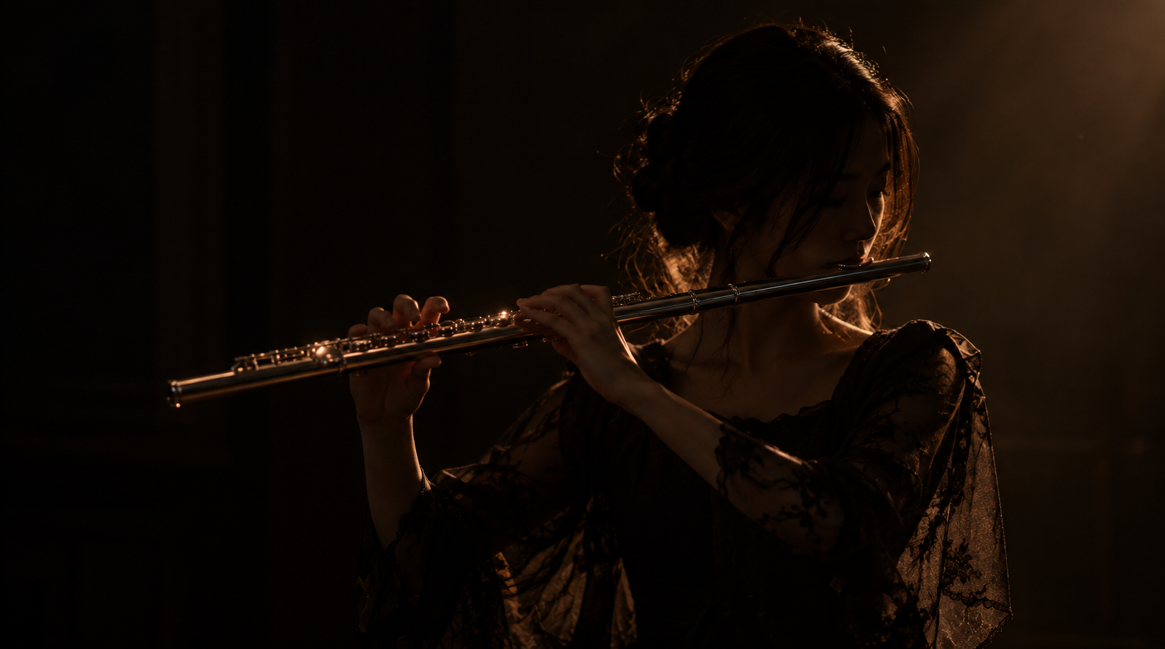 A flautist in a black lace dress playing a silver flute